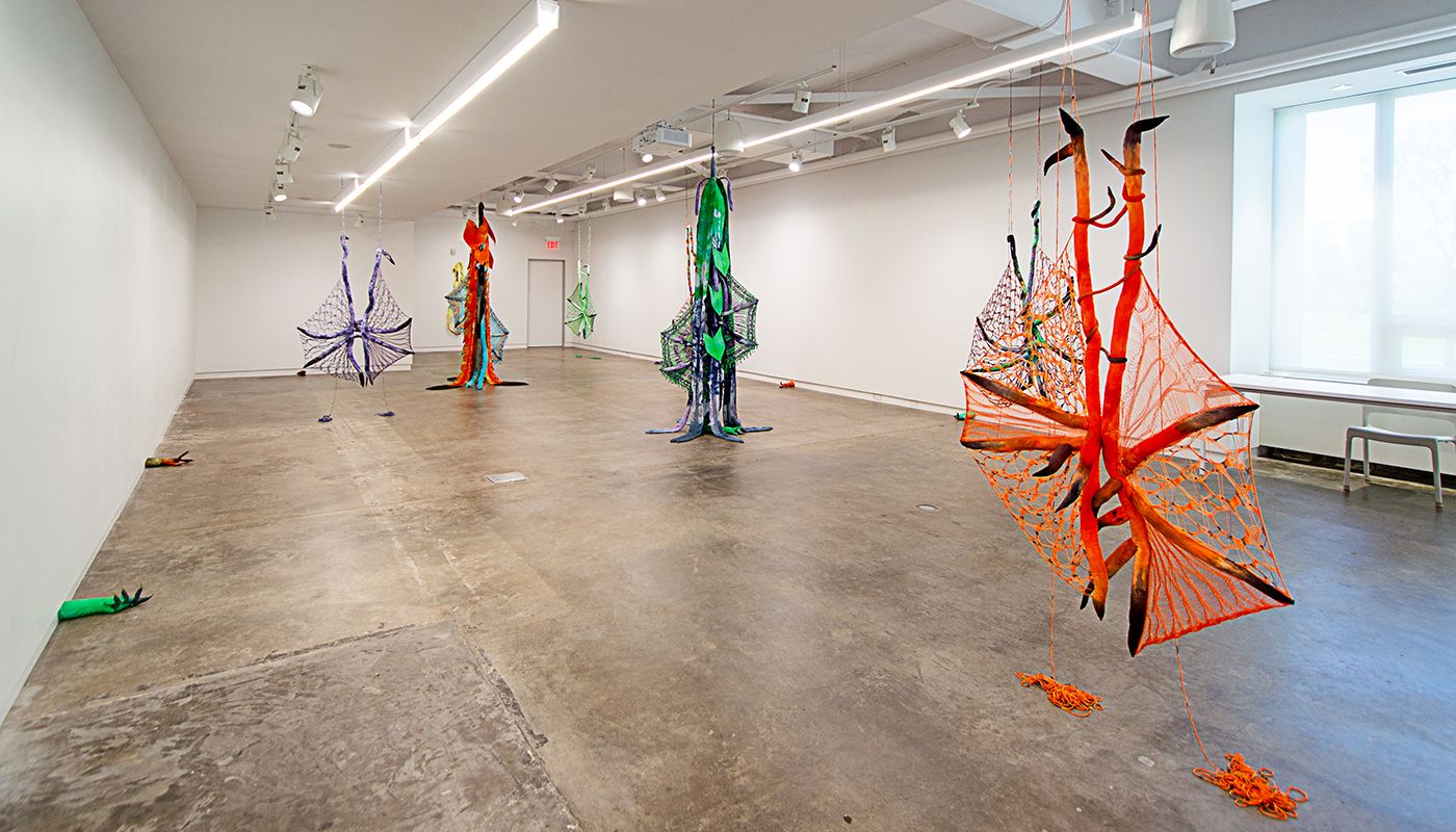 Installation of soft sculptures shaped most in large bat-like wings where the membranes are knitted with beads and hands with nails.
