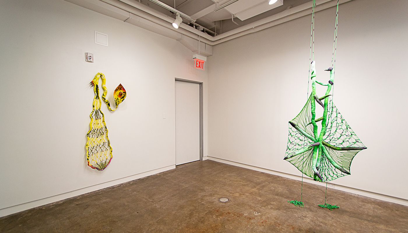 Installation of soft sculptures shaped most in large bat-like wings where the membranes are knitted with beads and hands with nails.