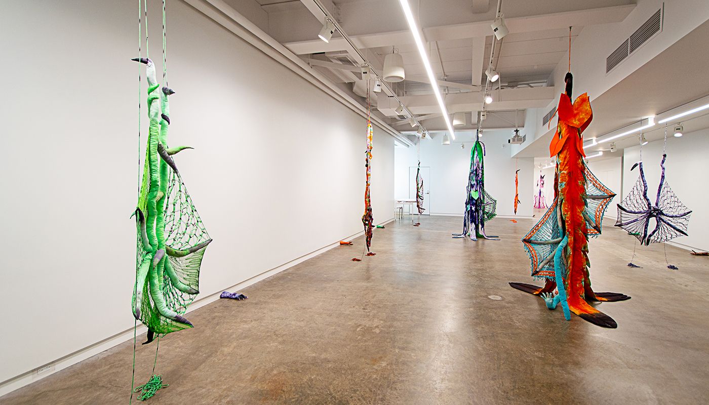 Installation of soft sculptures shaped most in large bat-like wings where the membranes are knitted with beads and hands with nails.