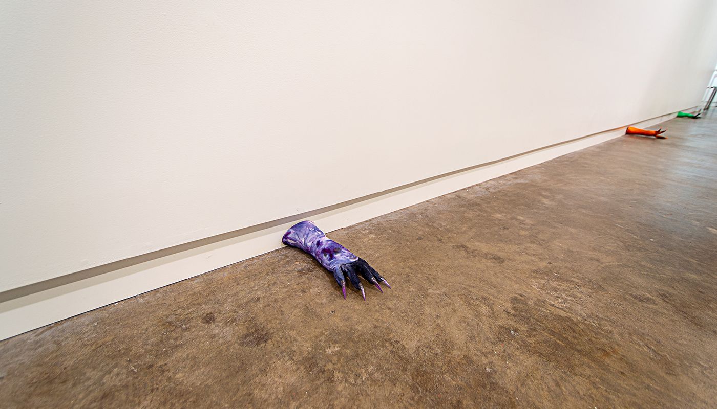 Installation of soft sculptures shaped most in large bat-like wings where the membranes are knitted with beads and hands with nails.