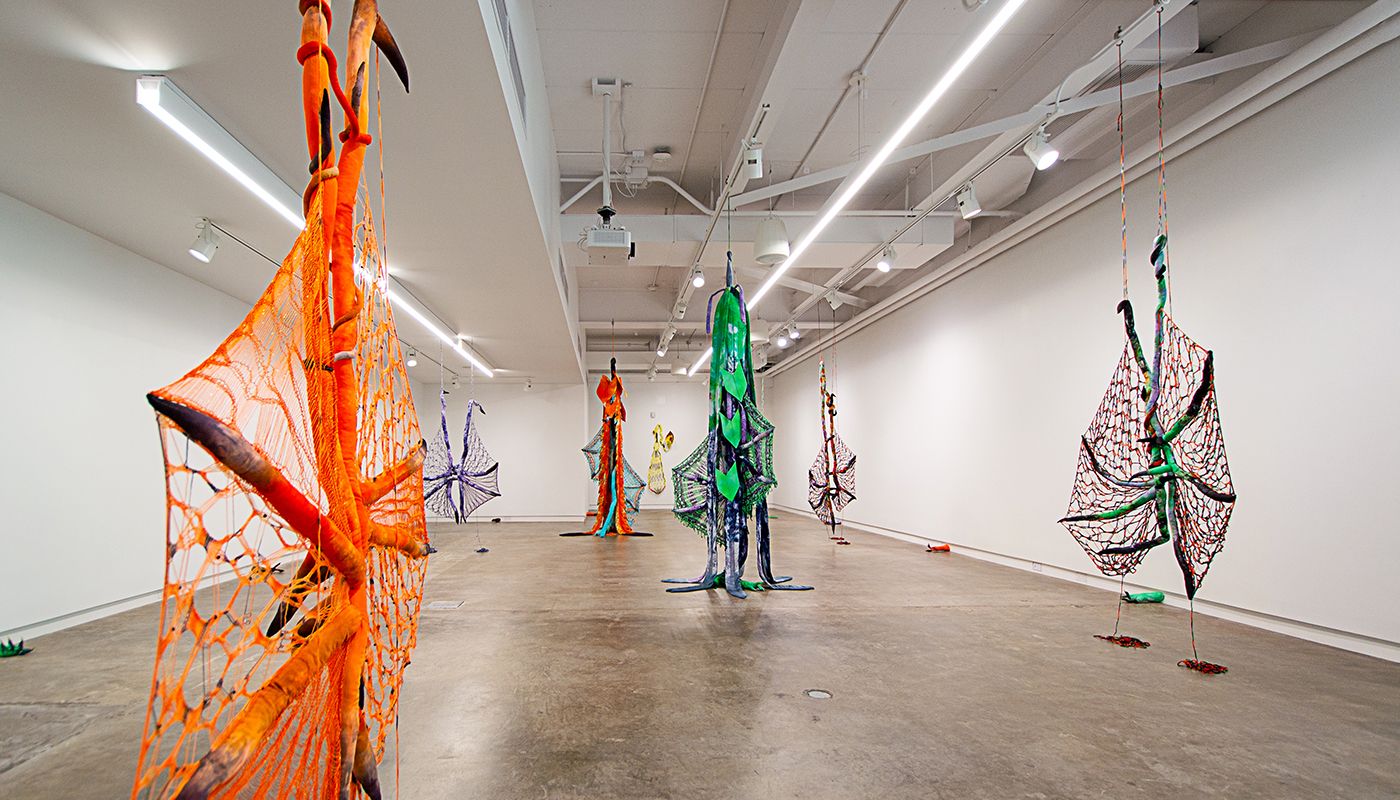 Installation of soft sculptures shaped most in large bat-like wings where the membranes are knitted with beads and hands with nails.