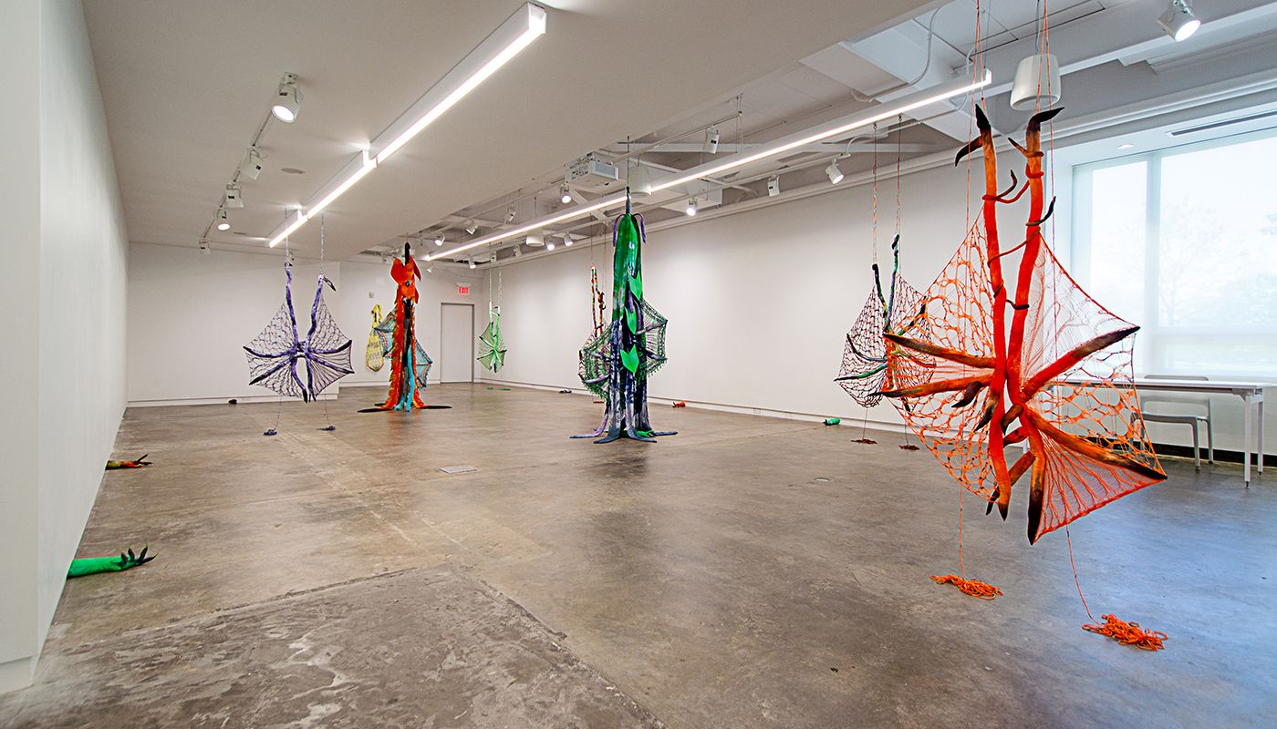 Installation of soft sculptures shaped most in large bat-like wings where the membranes are knitted with beads and hands with nails.
