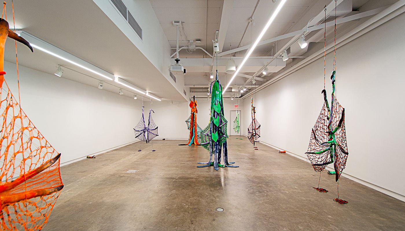 Installation of soft sculptures shaped most in large bat-like wings where the membranes are knitted with beads and hands with nails.