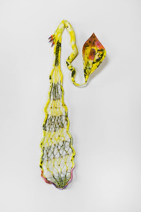 Hand-dyed wall sculpture primarily in yellow, this soft sculpture has a limp wrist with a conjoined long index and thumb with a knitted membrane with a hybrid spadix plant. 