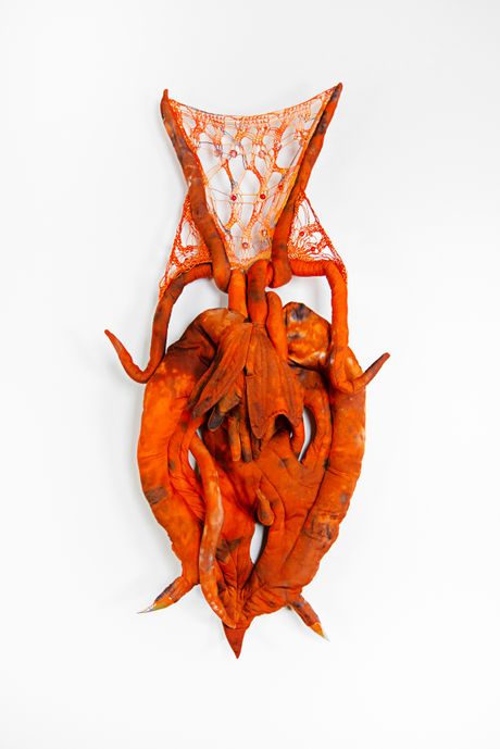 Hand dyed soft sculpture shaped like a budding plant with wings where the membranes are knitted with beads.