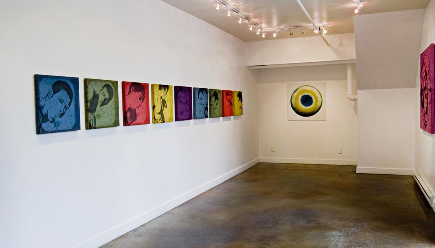 Installation shot of solo show consisting of woodcuts and one large photograph in primary colors.