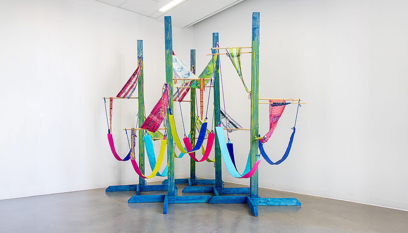 Colorful woven forms using backstrap weaving on posts installation.