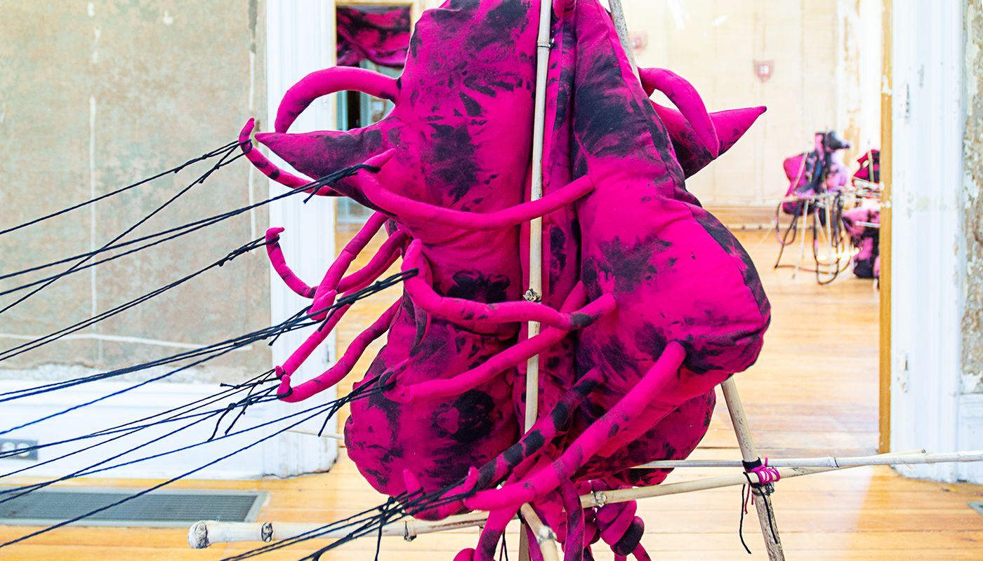 Free standing soft sculpture tie dyed in black and shades of pink supported in bamboo that are tied using square lashing knots.