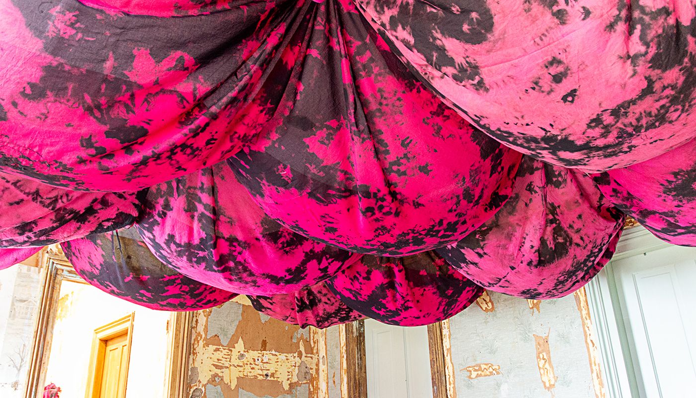 Bulbous voile fabric on the ceiling dyed in pink and black.