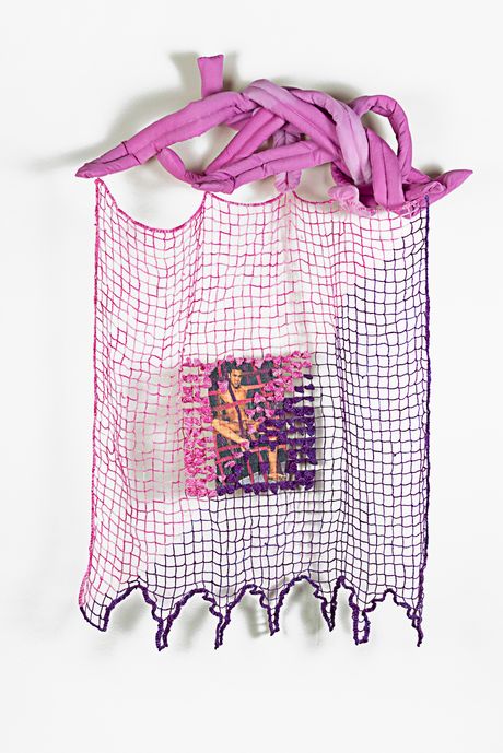 Wall sculpture in pink and purple. The top part is a soft sculpture shaped into several long pink tongues jumbled together. The bottom part is a rectangular filet lace with a detailed embroidered image in the middle that has been dye sublimated and then embellished with dimensional pointed stitches.